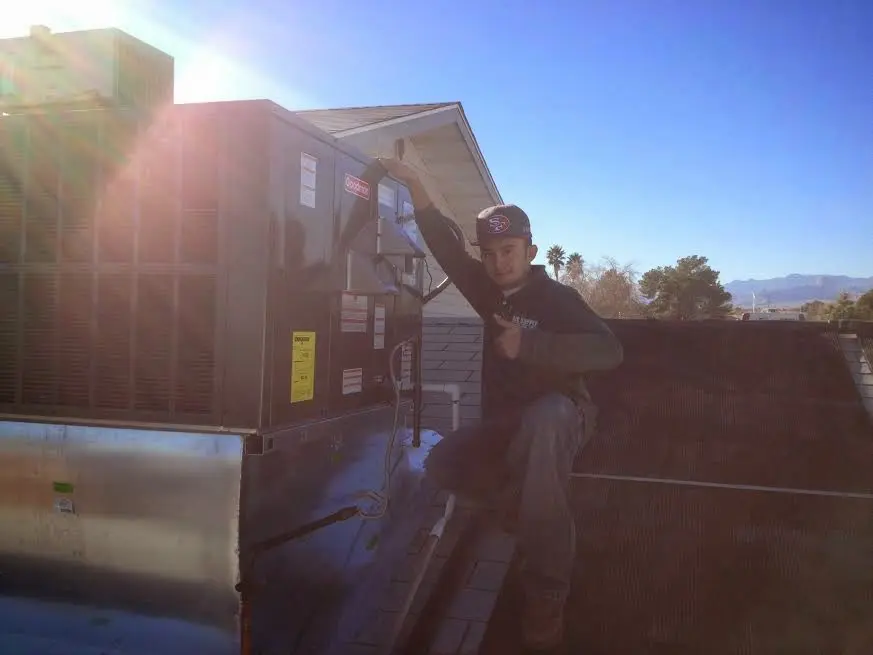HVAC technician performing AC Tune-Up on a rooftop unit in Bonita